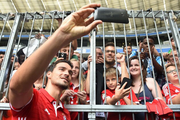 Bayern Munich's new defender Mats Hummels takes a selfie with supporters after a training session of the German first division Bundesliga club FC Bayern Munich in the stadium in Munich, southern Germany, on August 6, 2016.  / AFP / CHRISTOF STACHE        (Photo credit should read CHRISTOF STACHE/AFP/Getty Images)