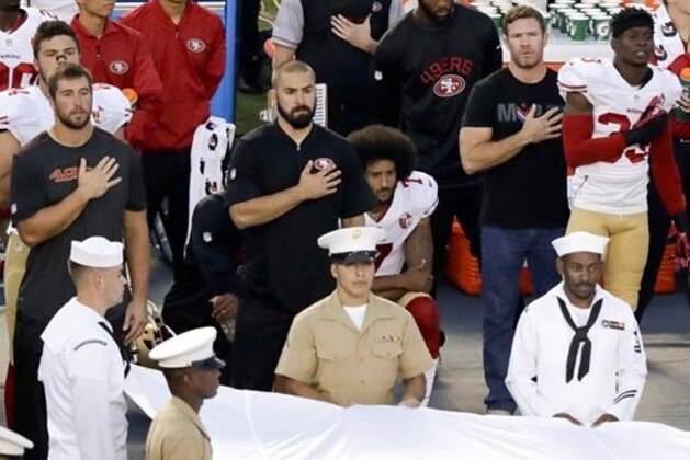 San Francisco 49ers quarterback Colin Kaepernick, middle, sits during the National Anthem before an NFL preseason football game against the San Diego Chargers, Thursday, Sept. 1, 2016, in San Diego. (AP Photo/Chris Carlson)
