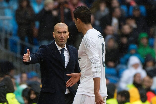 Real Madrid's French coach Zinedine Zidane (L) congratulates Real Madrid's French defender Raphael Varane as he leaves the pitch during the Spanish league football match Real Madrid CF vs Athletic Club Bilbao at the Santiago Bernabeu stadium in Madrid on February 13, 2016. / AFP / CURTO DE LA TORRE        (Photo credit should read CURTO DE LA TORRE/AFP/Getty Images)