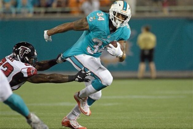 Miami Dolphins running back Arian Foster (34) slips past Atlanta Falcons strong safety Keanu Neal (22) for yardage during the first half of an NFL preseason football game in Orlando, Fla., Thursday, Aug. 25, 2016.(AP Photo/Phelan M. Ebenhack)