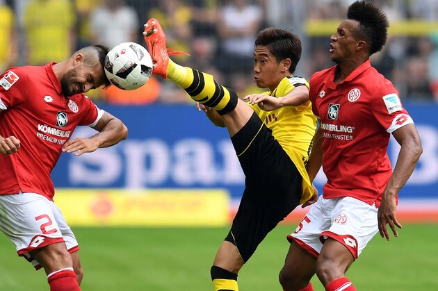 TOPSHOT - Dortmund's Japanese midfielder Shinji Kagawa (C) vies for the ball with Mainz' Italian defender Giulio Donati (L) and Mainz' French midfielder Jean Philippe Gbamin (R) during the German first division Bundesliga football match of Borussia Dortmund vs FSV Mainz 05 in Dortmund, western Germany, on August 27, 2016. / AFP / PATRIK STOLLARZ / RESTRICTIONS: DURING MATCH TIME: DFL RULES TO LIMIT THE ONLINE USAGE TO 15 PICTURES PER MATCH AND FORBID IMAGE SEQUENCES TO SIMULATE VIDEO. == RESTRICTED TO EDITORIAL USE == FOR FURTHER QUERIES PLEASE CONTACT DFL DIRECTLY AT + 49 69 650050
        (Photo credit should read PATRIK STOLLARZ/AFP/Getty Images)