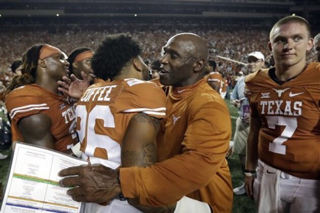 Texas head coach Charlie Strong, center, celebrates with Eric Cuffee (26) and quarterback Shane Buechele (7) after the team's win over Notre Dame in a NCAA college football game, Sunday, Sept. 4, 2016, in Austin, Texas. (AP Photo/Eric Gay)