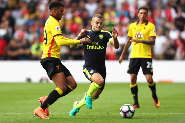 WATFORD, ENGLAND - AUGUST 27: Etienne Capoue of Watford (L) and Jack Wilshere of Arsenal (C) both challenge for the ball during the Premier League match between Watford and Arsenal at Vicarage Road on August 27, 2016 in Watford, England.  (Photo by Christopher Lee/Getty Images)