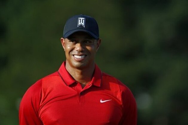 Tiger Woods stands on the 18th green during a trophy ceremony for Quicken Loans National PGA golf tournament winner Billy Hurley III, Sunday, June 26, 2016, in Bethesda, Md. (AP Photo/Patrick Semansky)