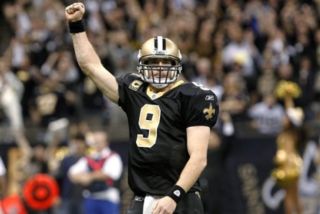 New Orleans Saints quarterback Drew Brees celebrates after throwing a touchdown pass and breaking the NFL single-season record for passing yardage, held by Dan Marino, in the fourth quarter of an NFL football game against the Atlanta Falcons in New Orleans, Monday, Dec. 26, 2011. (AP Photo/Rusty Costanza)
