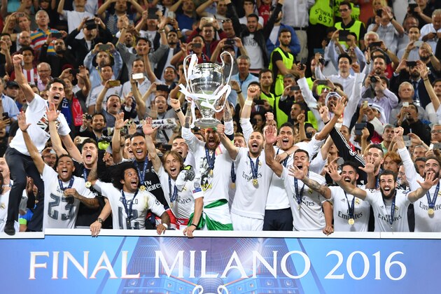 Real Madrid's Spanish defender Sergio Ramos (C) lifts the trophy as Real Madrid players celebrate winning the UEFA Champions League final football match over Atletico Madrid at San Siro Stadium in Milan, on May 28, 2016. / AFP / GERARD JULIEN        (Photo credit should read GERARD JULIEN/AFP/Getty Images)