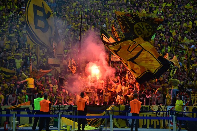 Dortmund fans light flares during the German Cup (DFB Pokal) final football match Bayern Munich vs Borussia Dortmund at the Olympic stadium in Berlin on May 21, 2016. / AFP / John MACDOUGALL / RESTRICTIONS: ACCORDING TO DFB RULES IMAGE SEQUENCES TO SIMULATE VIDEO IS NOT ALLOWED DURING MATCH TIME. MOBILE (MMS) USE IS NOT ALLOWED DURING AND FOR FURTHER TWO HOURS AFTER THE MATCH. == RESTRICTED TO EDITORIAL USE == FOR MORE INFORMATION CONTACT DFB DIRECTLY AT +49 69 67880

 /         (Photo credit should read JOHN MACDOUGALL/AFP/Getty Images)