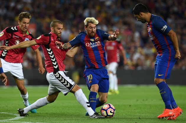 Barcelona's Argentinian forward Lionel Messi (2nd R) vies with Alaves' defender Victor Laguardia (2nd L) beside Barcelona's Uruguayan forward Luis Suarez (R) during the Spanish league football match FC Barcelona vs Deportivo Alaves at the Camp Nou stadium in Barcelona on September 10, 2016. / AFP / LLUIS GENE        (Photo credit should read LLUIS GENE/AFP/Getty Images)