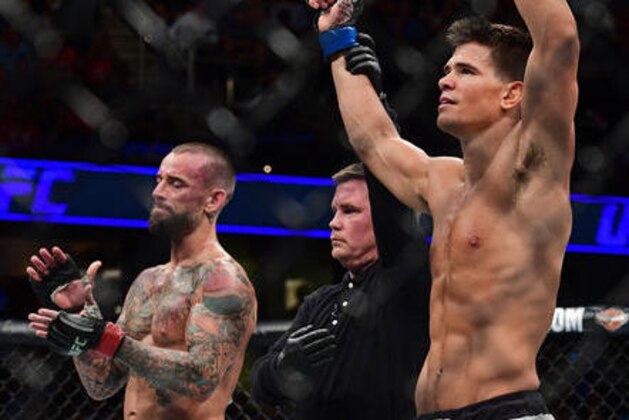 Mickey Gall has his arm raised by the referee after defeating CM Punk during a welterweight bout at UFC 203 on Saturday, Sept. 10, 2016, in Cleveland. (AP Photo/David Dermer)