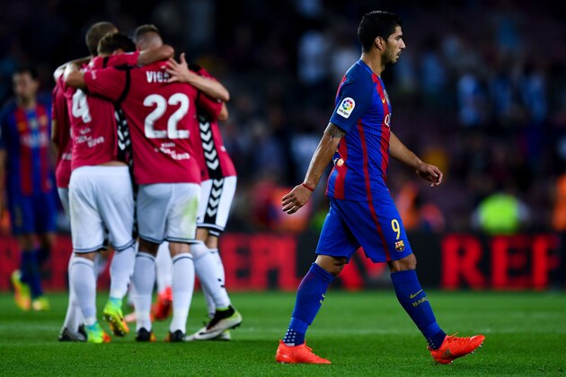 BARCELONA, SPAIN - SEPTEMBER 10:  Luis Suarez of FC Barcelona leaves the pitch dejected as Deportivo Alaves players celebrate victory at the end of the La Liga match between FC Barcelona and Deportivo Alaves at Camp Nou stadium on September 10, 2016 in Barcelona, Spain.  (Photo by David Ramos/Getty Images)