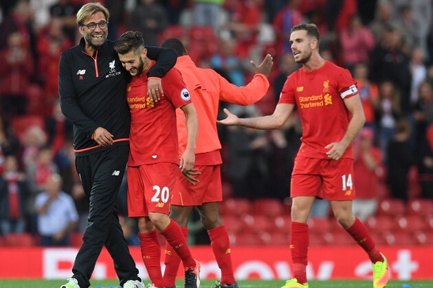 Liverpool's German manager Jurgen Klopp (L) celebrates on the pitch with Liverpool's English midfielder Adam Lallana (2nd L) after the English Premier League football match between Liverpool and Leicester City at Anfield in Liverpool, north west England on September 10, 2016.
Liverpool won the game 4-1. / AFP / Paul ELLIS / RESTRICTED TO EDITORIAL USE. No use with unauthorized audio, video, data, fixture lists, club/league logos or 'live' services. Online in-match use limited to 75 images, no video emulation. No use in betting, games or single club/league/player publications.  /         (Photo credit should read PAUL ELLIS/AFP/Getty Images)