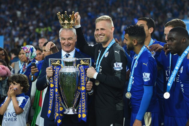 LEICESTER, ENGLAND - MAY 07:  Claudio Ranieri poses with the Premier League Trophy while Kasper Schmeichel puts the crown on the head of the manager as players and staffs celebrate the season champions after the Barclays Premier League match between Leicester City and Everton at the King Power Stadium on May 07, 2016 in Leicester, England.  (Photo by Shaun Botterill/Getty Images)