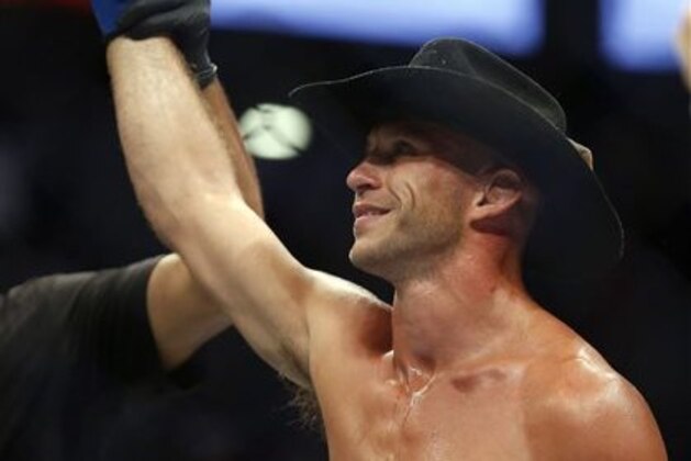 Donald Cerrone raises his hand after defeating Rick Story in a welterweight mixed martial arts bout at UFC 202 on Saturday, Aug. 20, 2016, in Las Vegas. (AP Photo/Isaac Brekken)