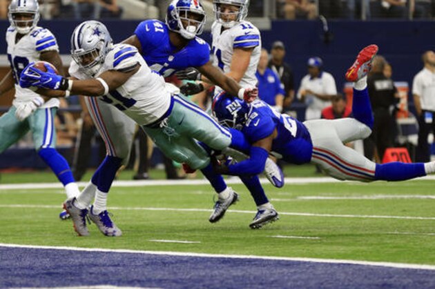 Dallas Cowboys running back Ezekiel Elliott (21) leaps into the end zone after getting past New York Giants cornerback Dominique Rodgers-Cromartie (41) and Nat Berhe (29) for his first career touchdown in the second half of an NFL football game, Sunday Sept. 11, 2016, in Arlington, Texas. (AP Photo/Ron Jenkins)