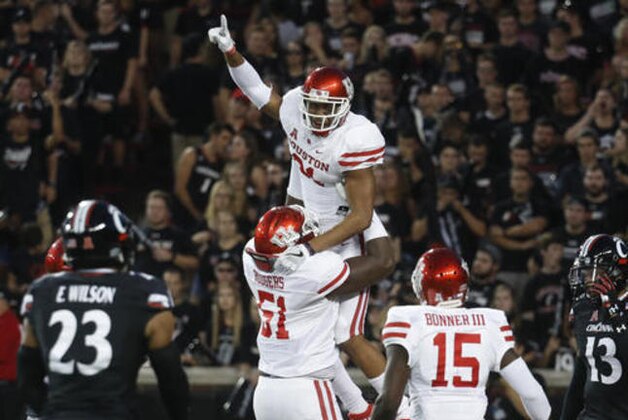 Houston wide receiver Chance Allen, top center, celebrates with offensive lineman Na'Ty Rodgers (51) after catching a touchdown pass against Cincinnati during the first half of an NCAA college football game Thursday, Sept. 15, 2016, in Cincinnati. Cincinnati's Grant Coleman is at righ. (AP Photo/John Minchillo)