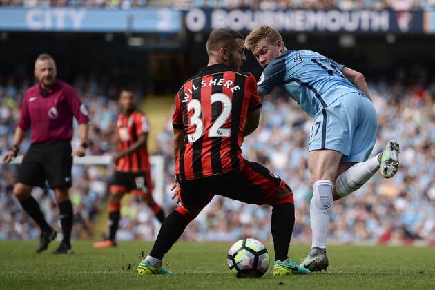 Manchester City's Belgian midfielder Kevin De Bruyne (R) back-heals the ball past Bournemouth's English midfielder Jack Wilshere during the English Premier League football match between Manchester City and Bournemouth at the Etihad Stadium in Manchester, north west England, on September 17, 2016. / AFP / OLI SCARFF / RESTRICTED TO EDITORIAL USE. No use with unauthorized audio, video, data, fixture lists, club/league logos or 'live' services. Online in-match use limited to 75 images, no video emulation. No use in betting, games or single club/league/player publications.  /         (Photo credit should read OLI SCARFF/AFP/Getty Images)