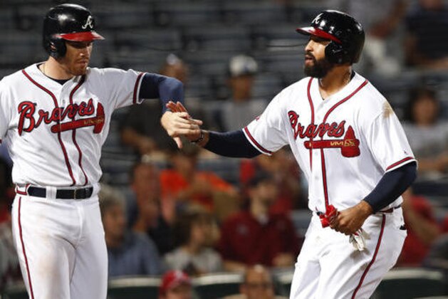 Atlanta Braves Matt Kemp, right, and Freddie freeman celebrate after scoring on a two-run base hit by Tyler Flowers in the eighth inning of a baseball game in Atlanta, on Monday Sept. 12, 2016. Atlanta won 12-7. (AP Photo/John Bazemore)