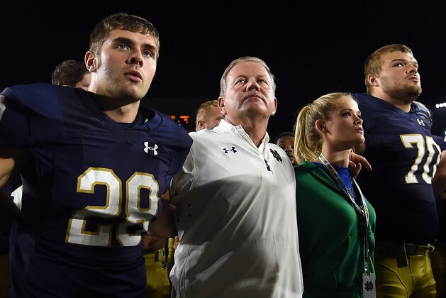 SOUTH BEND, IN - SEPTEMBER 17:  (L-R) Sam Kohler #29, head coach Brian Kelly, Grace Kelly and Hunter Bivin #70 of the Notre Dame Fighting Irish sing the alma mater following a loss to the Michigan State Spartans of the Notre Dame Fighting Irish at Notre Dame Stadium on September 17, 2016 in South Bend, Indiana.  Michigan State defeated Notre Dame 36-28. (Photo by Stacy Revere/Getty Images)