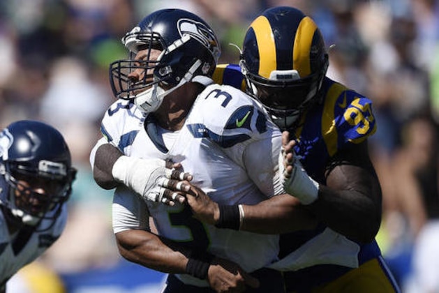 Seattle Seahawks quarterback Russell Wilson, left, is hit by Los Angeles Rams defensive end William Hayes after passing during the first half an NFL football game at the Los Angeles Memorial Coliseum, Sunday, Sept. 18, 2016, in Los Angeles. (AP Photo/Kelvin Kuo)