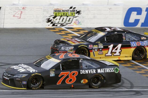 Martin Truex Jr. (78) drives past Tony Stewart (14) during a NASCAR Sprint Cup Series auto race at Chicagoland Speedway, Sunday, Sept. 18, 2016, in Joliet, Ill. (AP Photo/Nam Y. Huh)