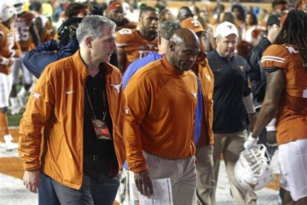 Texas coach Charlie Strong, center, walks off the field after Texas Tech defeated Texas 48-45 in an NCAA college football game Thursday, Nov. 26, 2015, in Austin, Texas. (AP Photo/Michael Thomas)