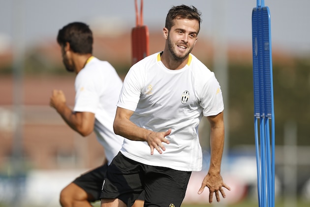 Juventus' Bosnian midfielder Miralem Pjanic (R)takes part in a training session on the eve of the UEFA Champions League football match Juventus vs FC Sevilla on September 13, 2016 at the Juventus Training Centre in Vinovo, near Turin.  / AFP / MARCO BERTORELLO        (Photo credit should read MARCO BERTORELLO/AFP/Getty Images)