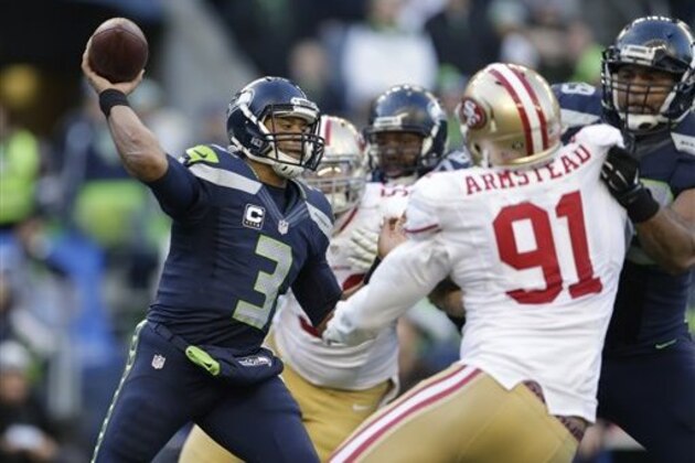 Seattle Seahawks quarterback Russell Wilson (3) passes under pressure from San Francisco 49ers defensive end Arik Armstead (91) in the second half of an NFL football game, Sunday, Nov. 22, 2015, in Seattle. (AP Photo/John Froschauer)