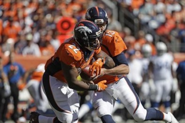 Denver Broncos quarterback Trevor Siemian hands off to C.J. Anderson (22)  against the Indianapolis Colts during the first half in a NFL football game, Sunday, Sept. 18, 2016, in Denver. (AP Photo/Jack Dempsey)
