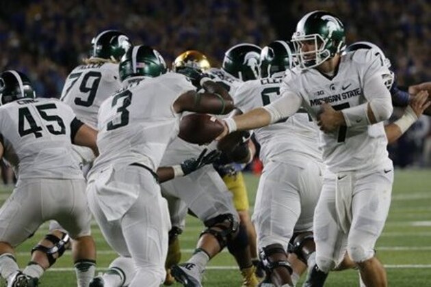 Michigan State quarterback Tyler O'Connor, right, hands off to running back LJ Scott during the first half of an NCAA college football game against Notre Dame Saturday, Sept. 17, 2016, in South Bend, Ind. (AP Photo/Charles Rex Arbogast)