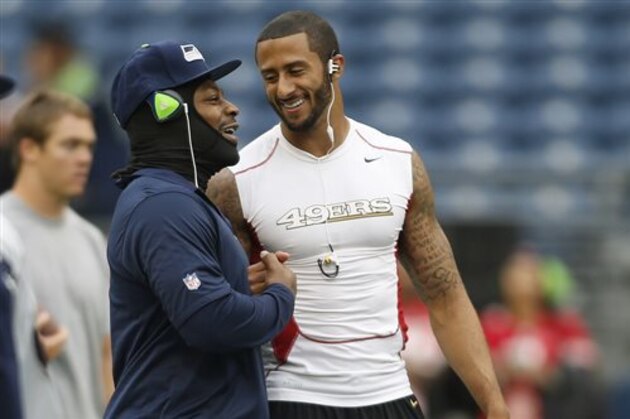 Seattle Seahawks running back Marshawn Lynch, left, talks with San Francisco 49ers quarterback Colin Kaepernick, right, on the field prior to an NFL football game, Sunday, Sept. 15, 2013, in Seattle. (AP Photo/John Froschauer)