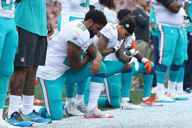 FOXBORO, MA - SEPTEMBER 18:  (L-R) Arian Foster #29, Kenny Stills #10 and Michael Thomas #31 of the Miami Dolphins kneel during the national anthem before the game against the New England Patriots at Gillette Stadium on September 18, 2016 in Foxboro, Massachusetts.  (Photo by Maddie Meyer/Getty Images)