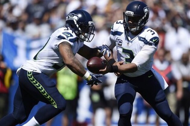 Seattle Seahawks quarterback Russell Wilson (3) hands the ball off to running back Thomas Rawls (34) during the first half an NFL football game against the Los Angeles Rams at the Los Angeles Memorial Coliseum, Sunday, Sept. 18, 2016, in Los Angeles. (AP Photo/Kelvin Kuo)