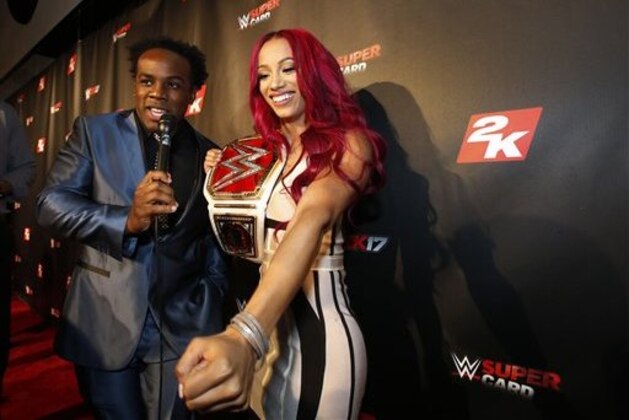 IMAGE DISTRIBUTED FOR 2K - WWE Women's Champion Sasha Banks speaks with WWE Superstar Xavier Woods, left, on the red carpet at the WWE 2K17 SummerSlam Kickoff Event in New York, on Friday, Aug. 19, 2016. (Adam Hunger/AP Images for 2K)
