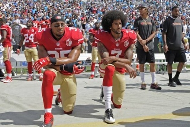 Colin Kaepernick (7) y Eric Reid, de los 49ers de San Francisco, se arrodillan durante la interpretación del himno nacional,antes de un partido de la NFL, frente a los Panthers de Carolina, el domingo 18 de septiembre de 2016 (AP Foto/Mike McCarn)