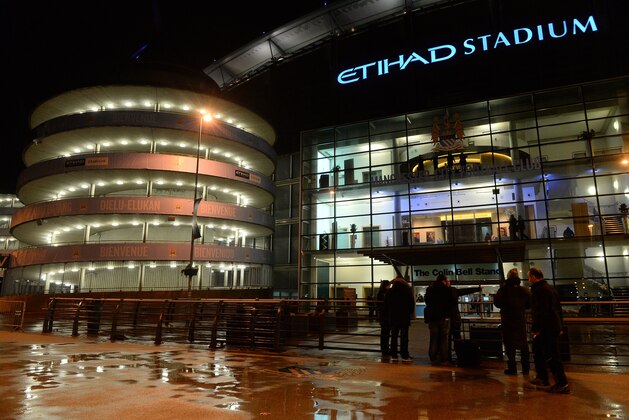 People walk past the outside of the Etihad Stadium in Manchester, north-west England, on February 12, 2014 after the English Premier League football match between Manchester City and Sunderland was postponed due to bad weather. The match was postponed as high winds battered the north-west of England. AFP PHOTO / ANDREW YATES 

RESTRICTED TO EDITORIAL USE. No use with unauthorized audio, video, data, fixture lists, club/league logos or live services. Online in-match use limited to 45 images, no video emulation. No use in betting, games or single club/league/player publications.        (Photo credit should read ANDREW YATES/AFP/Getty Images)