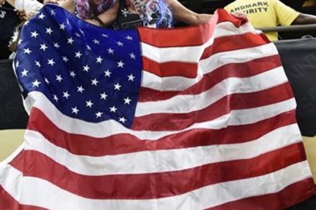 Oakland Raiders fans celebrate with an American flag in remembrance of the attacks of 9/11 in the second half of an NFL football game against the New Orleans Saints in New Orleans, Sunday, Sept. 11, 2016. (AP Photo/Bill Feig)