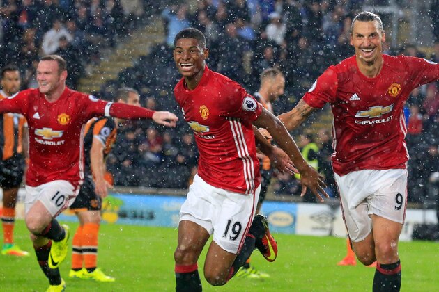 Manchester United's English striker Marcus Rashford (C) celebrates with Manchester United's Swedish striker Zlatan Ibrahimovic (R) and Manchester United's English striker Wayne Rooney (L) after scoring their late winning goal during the English Premier League football match between Hull City and Manchester United at the KCOM Stadium in Kingston upon Hull, north east England on August 27, 2016.
Manchester united won the game 1-0. / AFP / Lindsey PARNABY / RESTRICTED TO EDITORIAL USE. No use with unauthorized audio, video, data, fixture lists, club/league logos or 'live' services. Online in-match use limited to 75 images, no video emulation. No use in betting, games or single club/league/player publications.  /         (Photo credit should read LINDSEY PARNABY/AFP/Getty Images)