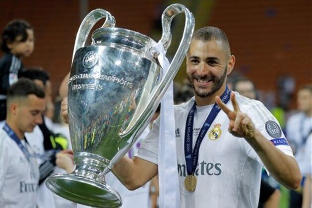 Real Madrid's Karim Benzema celebrates with the trophy after the Champions League final soccer match between Real Madrid and Atletico Madrid at the San Siro stadium in Milan, Italy, Saturday, May 28, 2016. Real Madrid won 5-3 on penalties after the match ended 1-1 after extra time.     (AP Photo/Manu Fernandez)