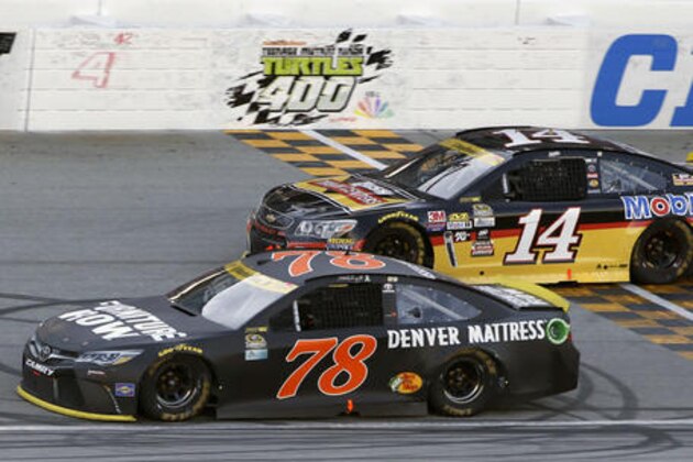 Martin Truex Jr. (78) drives past Tony Stewart (14) during a NASCAR Sprint Cup Series auto race at Chicagoland Speedway, Sunday, Sept. 18, 2016, in Joliet, Ill. (AP Photo/Nam Y. Huh)