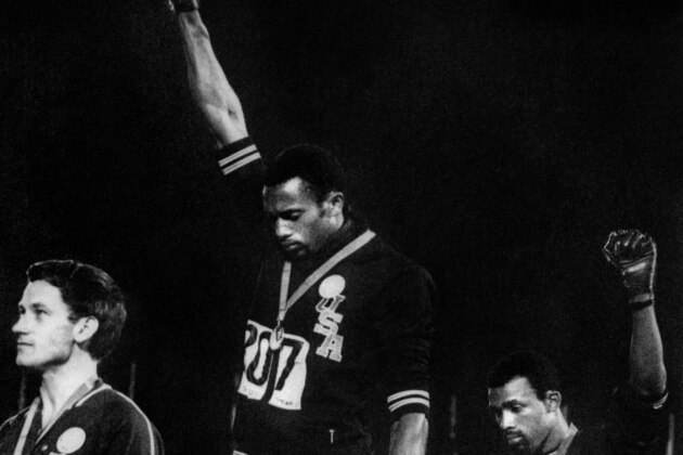 TO GO WITH AFP STORY BY JIM SLATER : 'Forty years after Tommie Smith and John Carlos raised their fists in a civil rights gesture on the Olympic medal stand in Mexico City, protests on the podium could make a comeback in Beijing.'. (FILES) US athletes Tommie Smith (C) and John Carlos (R) raise their gloved fists in the Black Power salute to express their opposition to racism in the USA during the US national anthem, after receiving their medals 17 October 1968 for first and third place in the men's 200m event at the Mexico Olympic Games. At left is Peter Norman of Australia who took second place. / AFP / EPU / -        (Photo credit should read -/AFP/Getty Images)