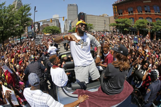 FILE - In this June 22, 2016, file photo, Cleveland Cavaliers' LeBron James, center, stands in the back of a Rolls-Royce as it makes it way through the crowd during a parade in downtown Cleveland celebrating the team's NBA championship. A person familiar with the contract says James has agreed to a three-year, $100 million contract with the Cavaliers. The person says James, who recently led the Cavs to an NBA title--the first for a Cleveland sport team in 52 years--will soon sign the deal. The person spoke to the Associated Press Thursday on condition of anonymity because some details of the deal need to be finalized. (AP Photo/Gene J. Puskar, File)