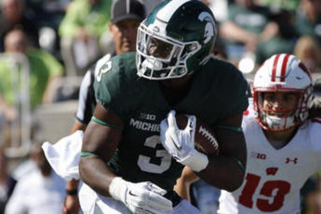 Michigan State running back LJ Scott spins for extra yardage against Wisconsin's Ryan Connelly, bottom right, and Leo Musso (19) during the second quarter of an NCAA college football game, Saturday, Sept. 24, 2016, in East Lansing, Mich. Wisconsin won 30-6. (AP Photo/Al Goldis)