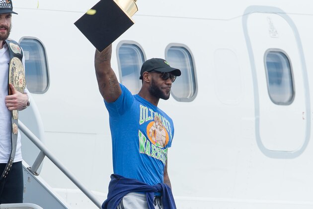 CLEVELAND, OH -  JUNE 20: LeBron James #23 of the Cleveland Cavaliers hoists the trophy as he gets off the plane as the team returns to Cleveland after wining the NBA Championships on June 20, 2016 in Cleveland, Ohio. (Photo by Jason Miller/Getty Images)