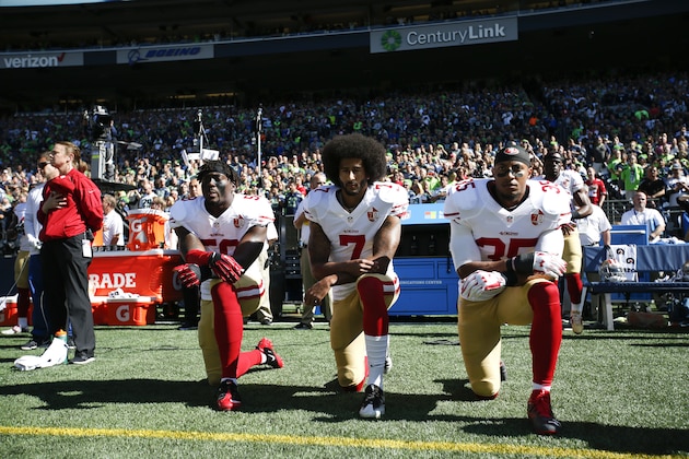 SEATTLE, WA - SEPTEMBER 25: Eli Harold #58, Colin Kaepernick #7 and Eric Reid #35 of the San Francisco 49ers kneel on the sideline during the anthem prior to the game against the Seattle Seahawks at CenturyLink Field on September 25, 2016 in Seattle, Washington. The Seahawks defeated the 49ers 38-18. (Photo by Michael Zagaris/San Francisco 49ers/Getty Images)