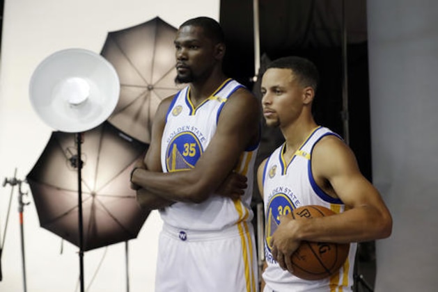 Golden State Warriors' Kevin Durant, left, and Stephen Curry pose for photos during NBA basketball media day Monday, Sept. 26, 2016, in Oakland, Calif. (AP Photo/Marcio Jose Sanchez)