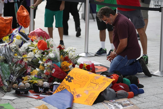 MIAMI, FL - SEPTEMBER 28:  People pay their respects at a memorial before the hearse carrying Miami Marlins pitcher Jose Fernandez passes in front of the Marlins baseball stadium on September 28, 2016 in Miami, Florida.  Mr. Fernandez was killed in a weekend boat crash in Miami Beach along with two friends.  (Photo by Joe Raedle/Getty Images)