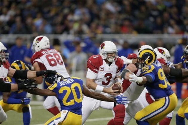 Arizona Cardinals quarterback Carson Palmer, left, is sacked for a 4-yard loss by St. Louis Rams defensive tackle Aaron Donald during the second quarter of an NFL football game on Sunday, Dec. 6, 2015, in St. Louis. (AP Photo/Tom Gannam)