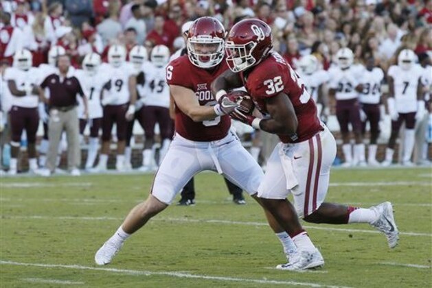 Oklahoma quarterback Baker Mayfield (6) hands off to running back Samaje Perine (32) during an NCAA college football game between Louisiana Monroe and Oklahoma in Norman, Okla., Saturday, Sept. 10, 2016. (AP Photo/Sue Ogrocki)