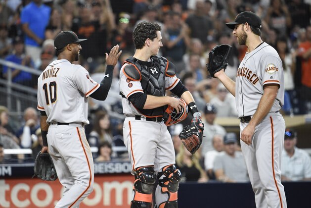 SAN DIEGO, CALIFORNIA - SEPTEMBER 24:  Eduardo Nunez #10 of the San Francisco Giants, left, is congratulated by Buster Posey #28, and Madison Bumgarner #40  after making the catch on a foul ball hit by Carlos Asuaje #63 of the San Diego Padres during the third inning of a baseball game at PETCO Park on September 24, 2016 in San Diego, California.  (Photo by Denis Poroy/Getty Images)