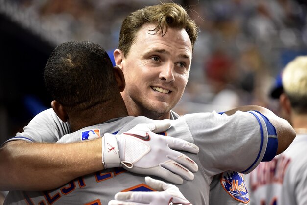 Sep 28, 2016; Miami, FL, USA; New York Mets right fielder Jay Bruce (right) is greeted by left fielder Yoenis Cespedes (left) in the dugout after Bruce hit a two run homer during the fifth inning against the Miami Marlins at Marlins Park. The Mets won 5-2. Mandatory Credit: Steve Mitchell-USA TODAY Sports